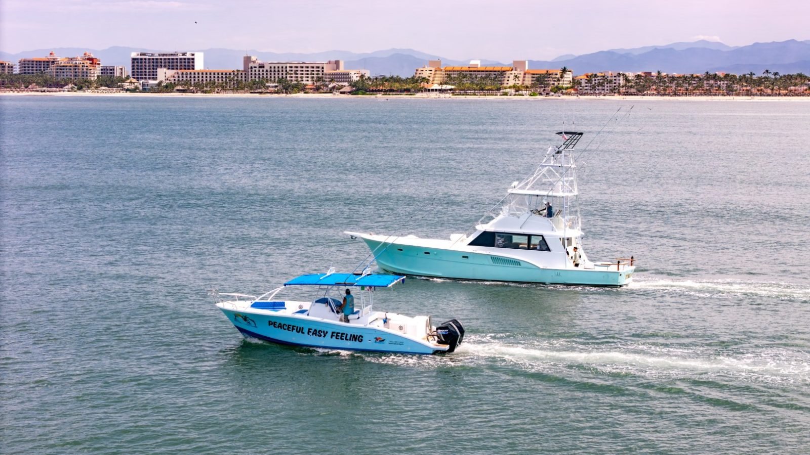 Los barcos Steel n Time y Peaceful Easy Feeling de Ol' Salty's Ranch navegando frente a la costa de Nuevo Vallarta